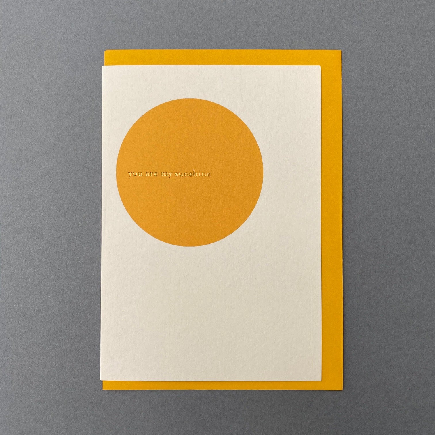 You Are My Sunshine greeting card with yellow envelope on a grey background
