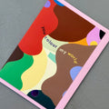Angled view of the You Colour My World greeting card with a soft pink envelope, showcasing the bold abstract design and contemporary illustration.