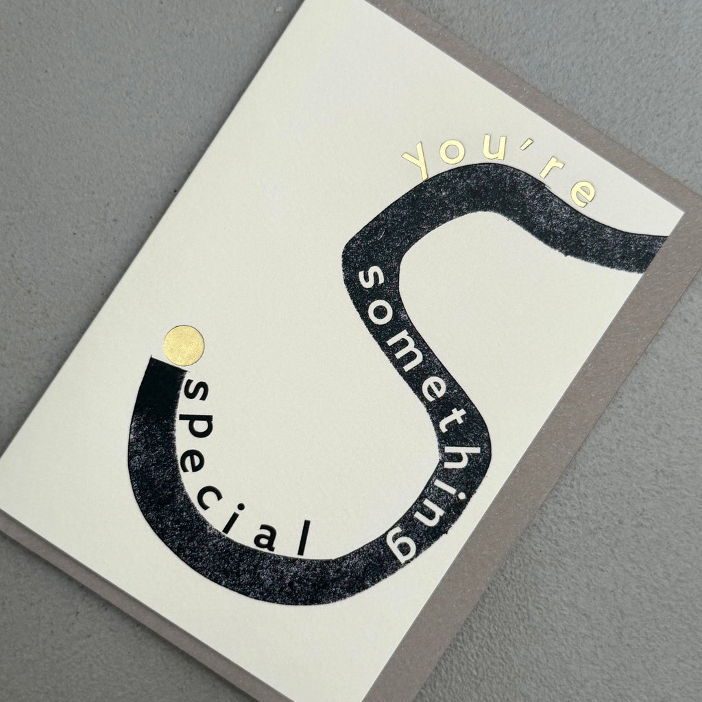 Angled view of You’re Something Special card by PAVILION with bold black curved typography, gold foil details and grey envelope