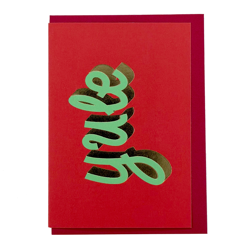 Front view of YULE Christmas card by PAVILION with green sculptural lettering on a vivid red background and red envelope